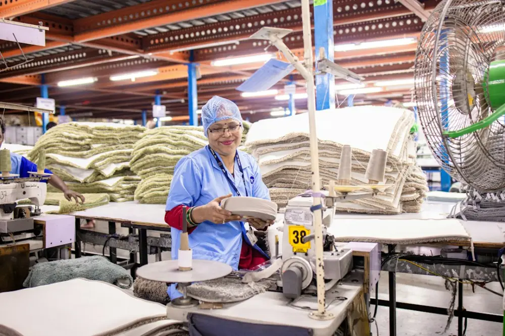 Woman working in a textile factory with materials, illustrating responsible sourcing and material lifecycle
